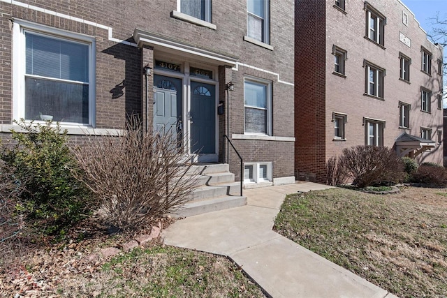 property entrance featuring brick siding