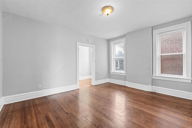 unfurnished room featuring baseboards and wood-type flooring