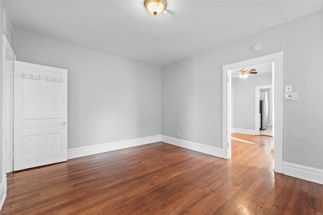 spare room with baseboards and wood-type flooring