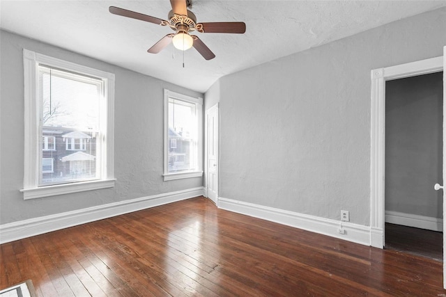 spare room featuring ceiling fan, baseboards, and wood-type flooring