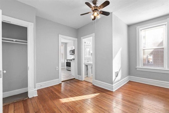 unfurnished bedroom featuring a closet, baseboards, and hardwood / wood-style floors