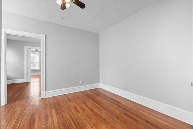 unfurnished room with baseboards, a ceiling fan, and hardwood / wood-style flooring