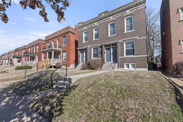 multi unit property featuring entry steps, brick siding, and a residential view