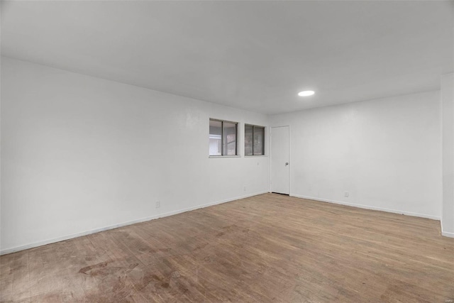 unfurnished room featuring recessed lighting, baseboards, and wood finished floors