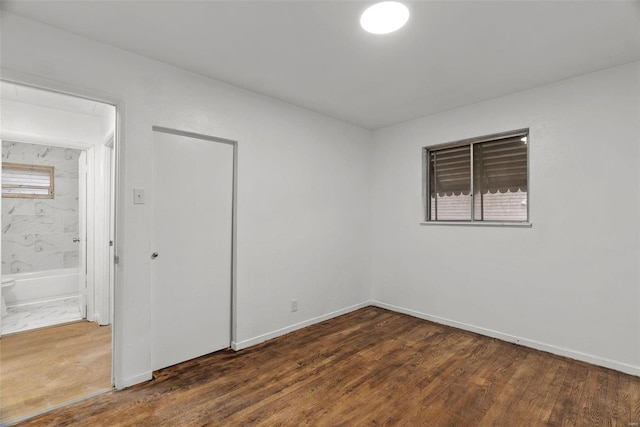 empty room featuring baseboards and wood finished floors