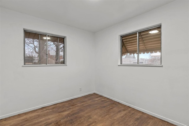 unfurnished room featuring baseboards and wood finished floors