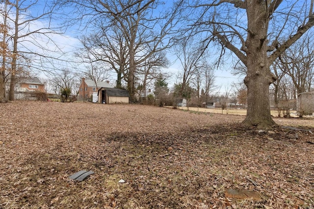 view of yard with a storage unit, an outbuilding, and fence