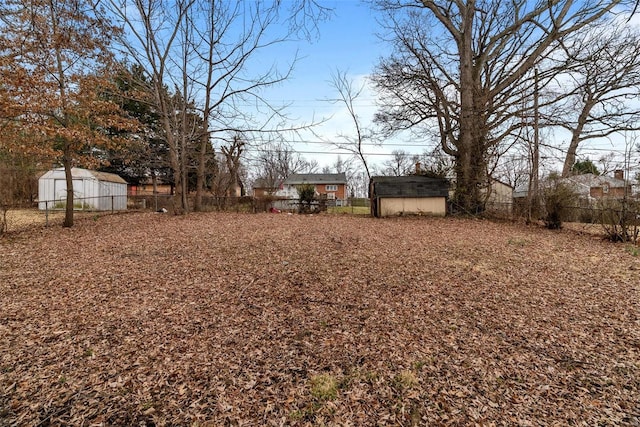 view of yard with an outbuilding, a storage unit, and a fenced backyard