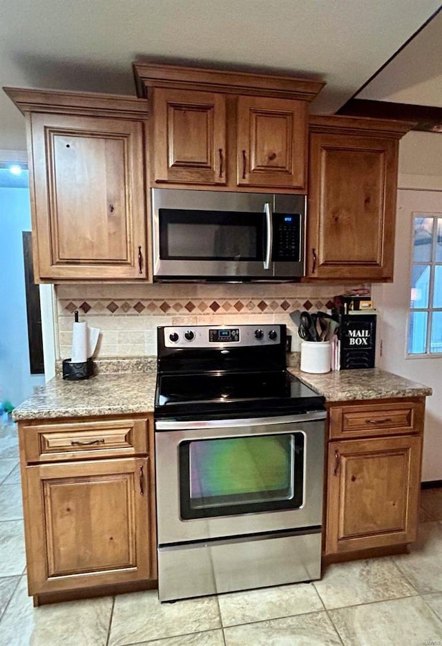 kitchen featuring stainless steel appliances, brown cabinets, and decorative backsplash