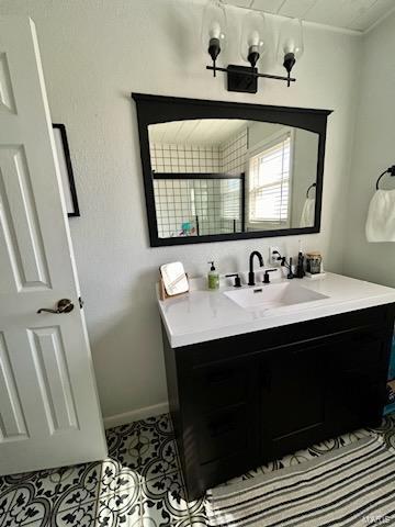 bathroom featuring tile patterned flooring, vanity, and baseboards