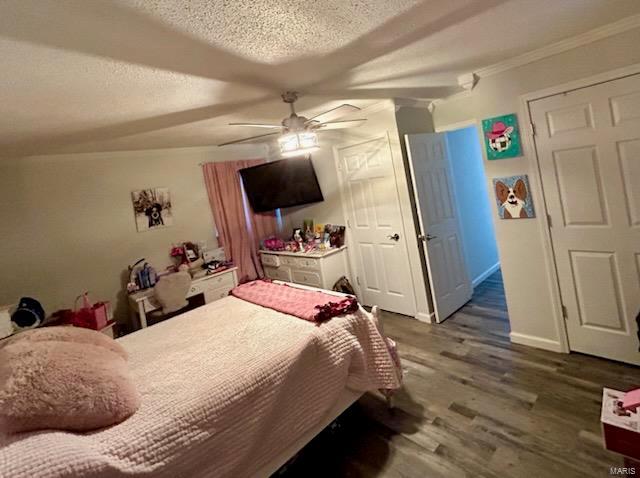 bedroom featuring a ceiling fan, wood finished floors, baseboards, a textured ceiling, and crown molding