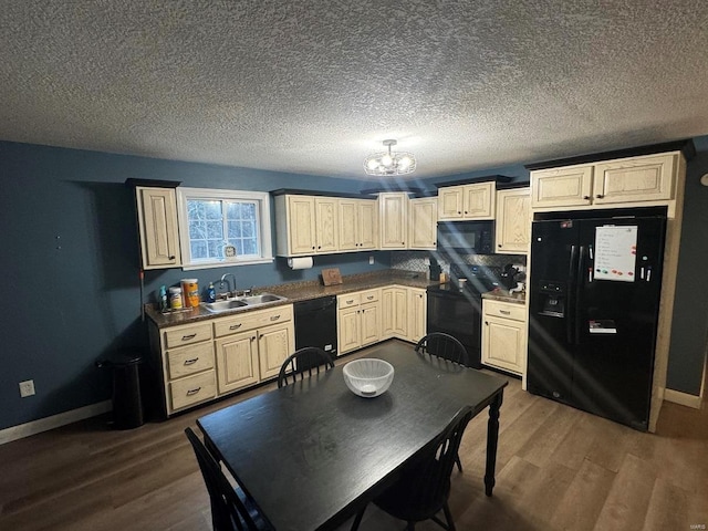 kitchen featuring black appliances, baseboards, dark wood finished floors, and a sink