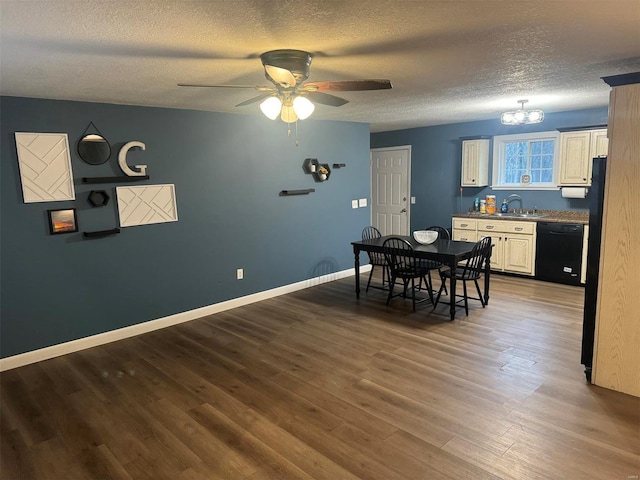 dining area with a textured ceiling, baseboards, wood finished floors, and ceiling fan with notable chandelier