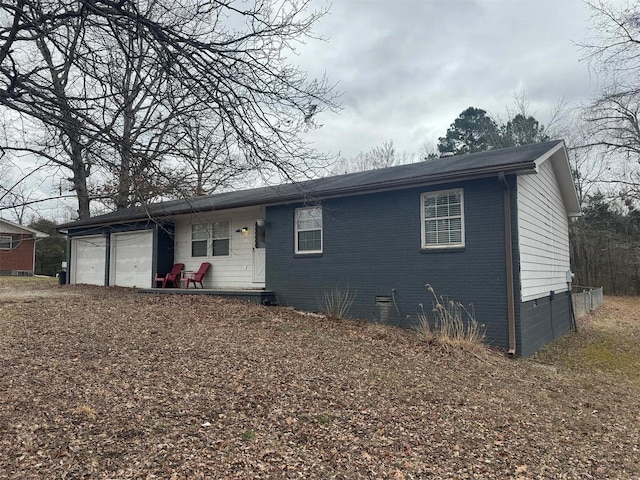 view of front of house with crawl space, an attached garage, and brick siding