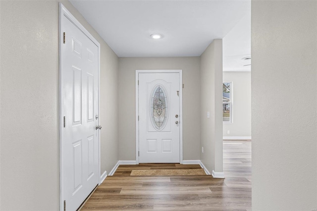 entryway featuring baseboards and wood finished floors