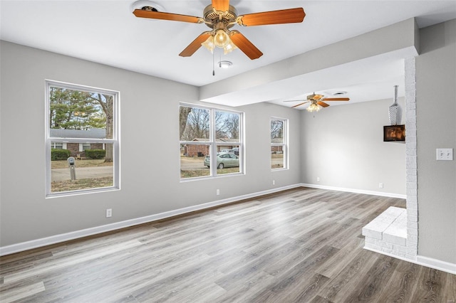 unfurnished room with ceiling fan, wood finished floors, and baseboards