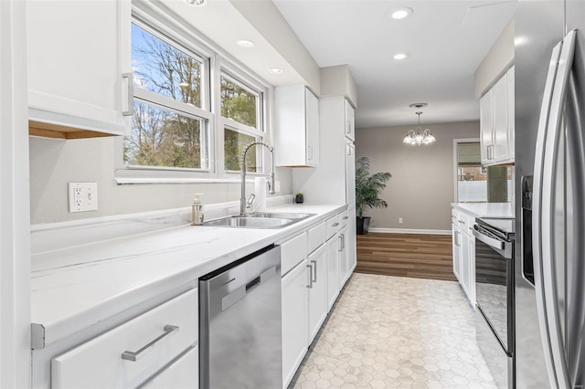 kitchen with stainless steel appliances, white cabinets, and a sink