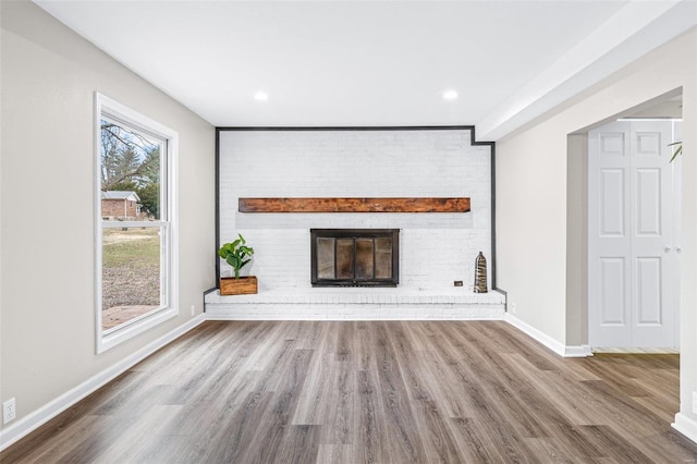 unfurnished living room with recessed lighting, a fireplace, wood finished floors, and baseboards