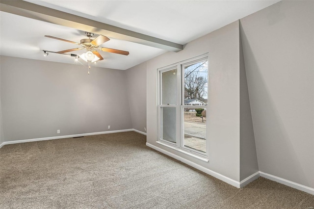 carpeted empty room with ceiling fan, baseboards, and beamed ceiling