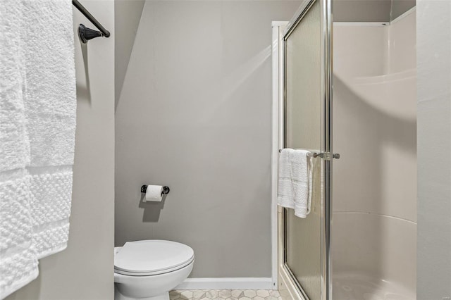 full bathroom featuring toilet, a shower stall, and baseboards