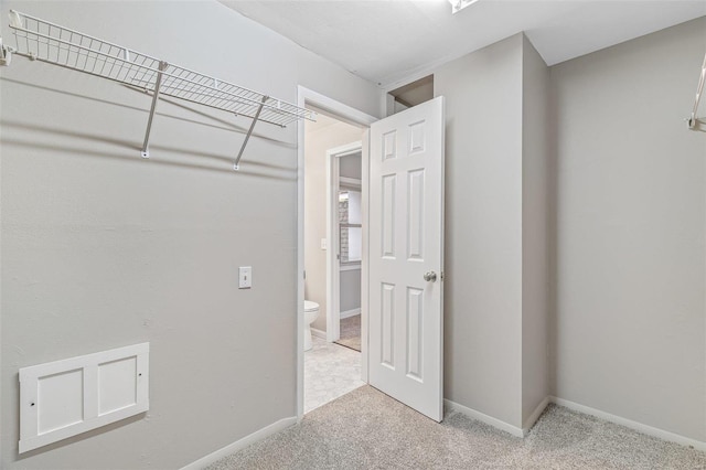 walk in closet featuring light carpet