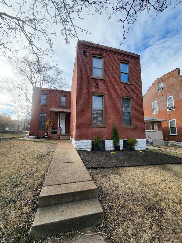 view of front facade with a front yard and brick siding