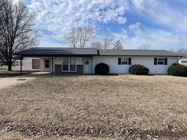 single story home with a carport, brick siding, a front lawn, and driveway