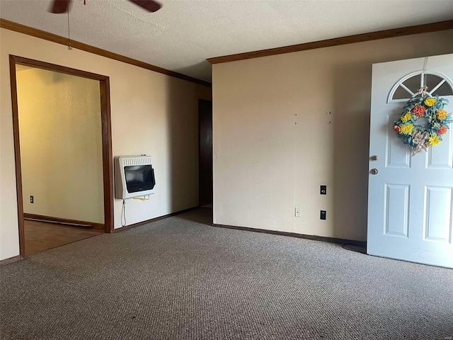 carpeted spare room featuring heating unit, baseboards, ornamental molding, and a textured ceiling