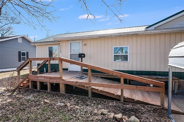 rear view of house featuring metal roof and a deck