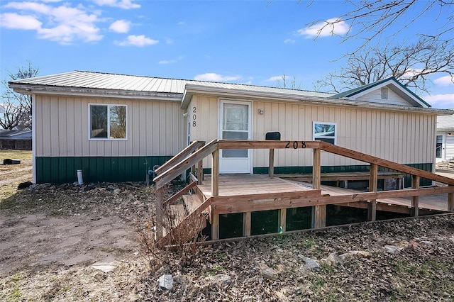 back of property with metal roof and a deck