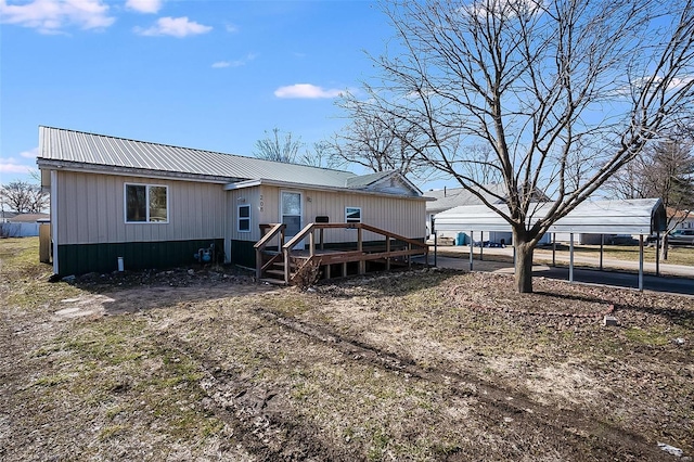 manufactured / mobile home with a deck, a carport, and metal roof