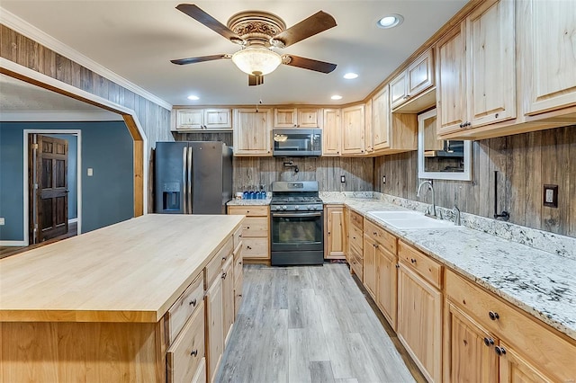 kitchen featuring refrigerator with ice dispenser, light brown cabinetry, a sink, stainless steel microwave, and gas range