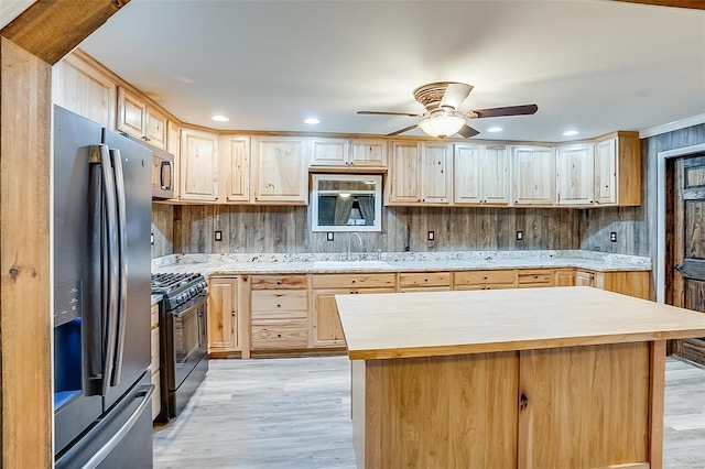 kitchen with a sink, light wood-style flooring, light brown cabinets, and stainless steel appliances