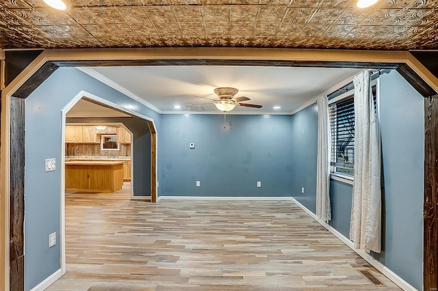 interior space featuring baseboards, an ornate ceiling, and crown molding