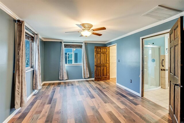 unfurnished bedroom with light wood finished floors, visible vents, crown molding, and baseboards