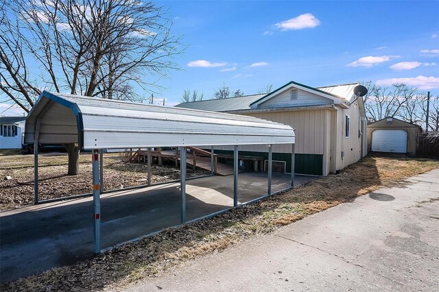 view of property exterior with a detached carport, metal roof, a detached garage, and an outdoor structure