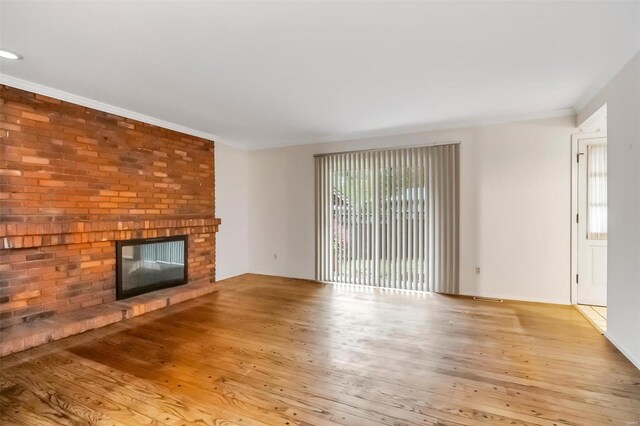 unfurnished living room with ornamental molding, hardwood / wood-style flooring, and a fireplace