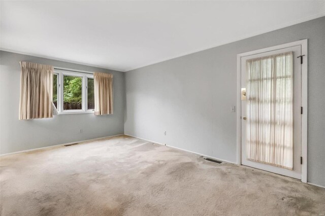 unfurnished room with visible vents, carpet, and baseboards