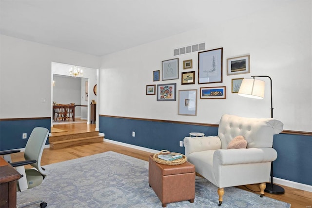 office with baseboards, visible vents, a chandelier, and wood finished floors