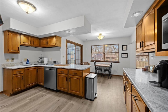 kitchen with dishwasher, a peninsula, light wood finished floors, and brown cabinets