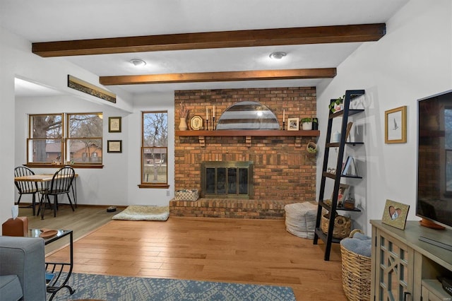 living room featuring a fireplace, beam ceiling, and wood finished floors