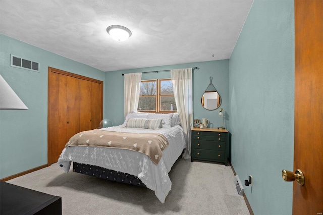 carpeted bedroom with a closet, visible vents, and baseboards