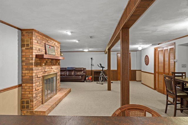 interior space featuring wooden walls, visible vents, wainscoting, carpet, and a brick fireplace