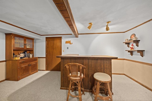 bar featuring a dry bar, baseboards, light carpet, and ornamental molding