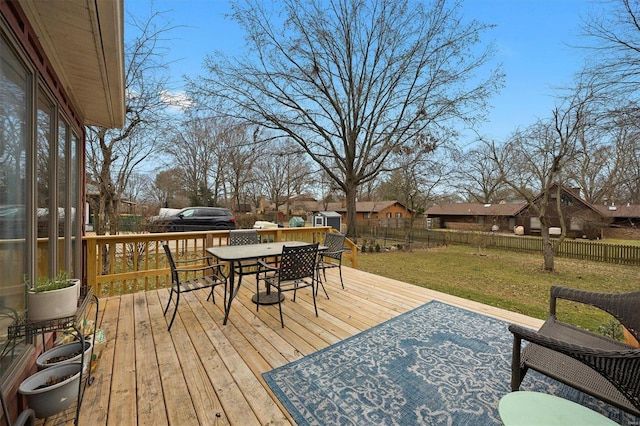 wooden terrace with a yard, outdoor dining space, and a fenced backyard