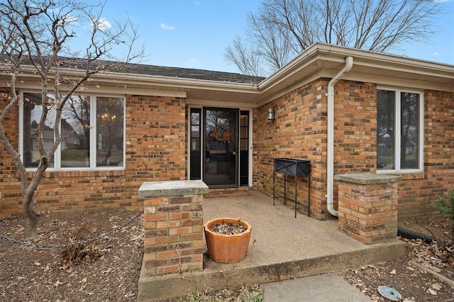 property entrance featuring brick siding