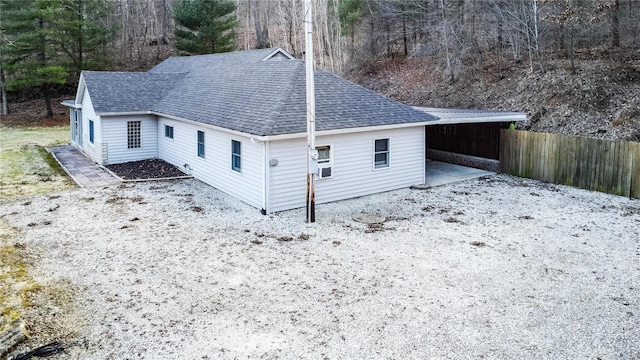 exterior space with roof with shingles and fence