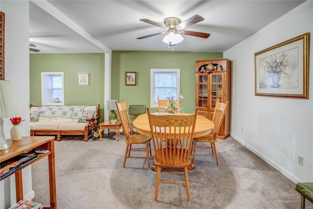 carpeted dining room with baseboards and ceiling fan