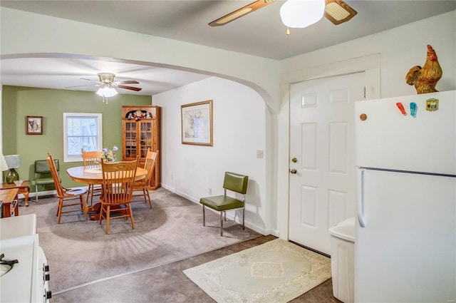 dining room with baseboards, arched walkways, and ceiling fan