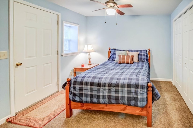 carpeted bedroom with a closet, baseboards, and ceiling fan